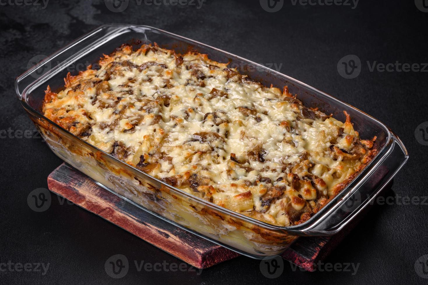 A delicious nutritious dish with meat, mushrooms, vegetables and potatoes, baked in a creamy sauce in an oven photo