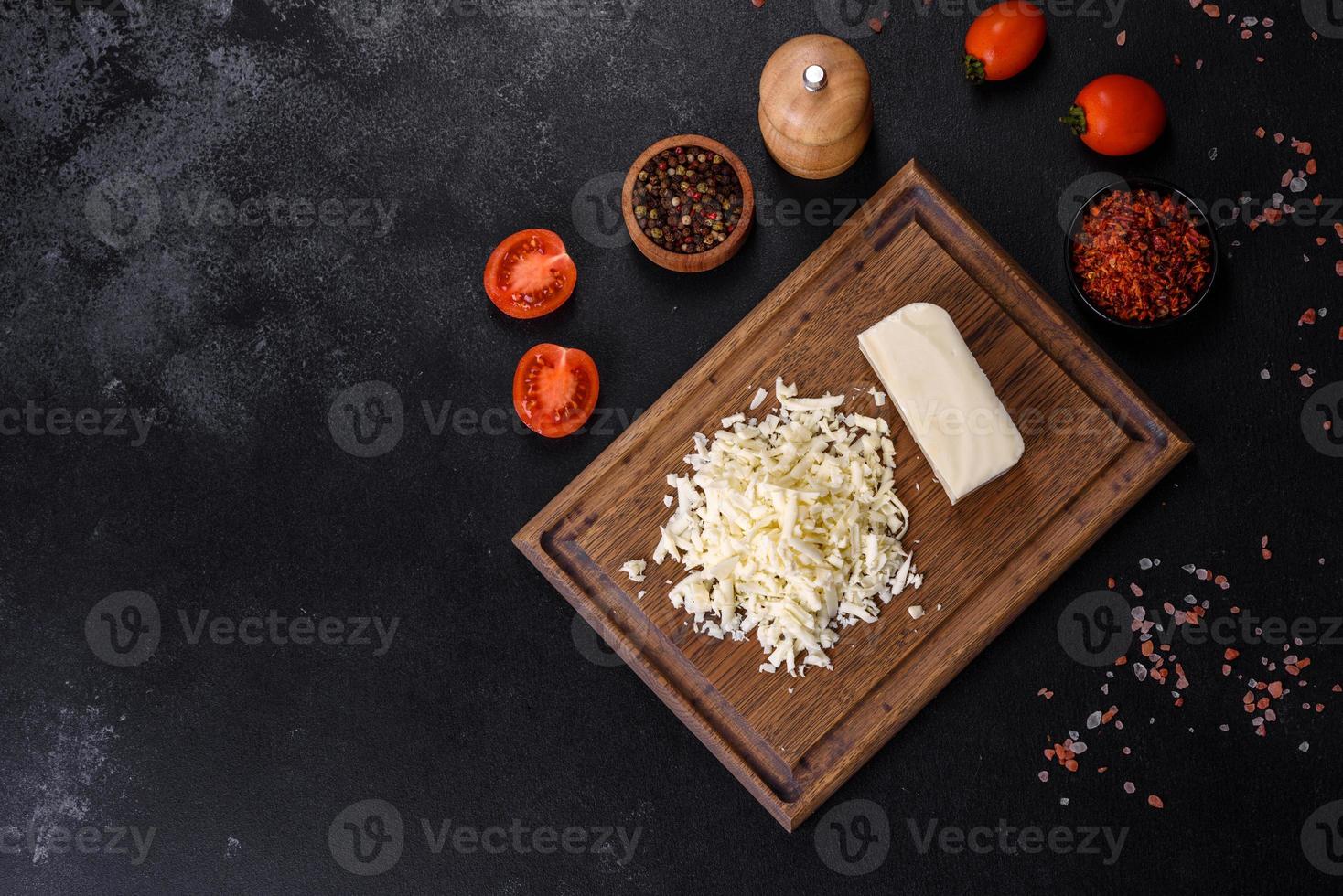 Image of a bar and grated mozzarella cheese on a dark background photo