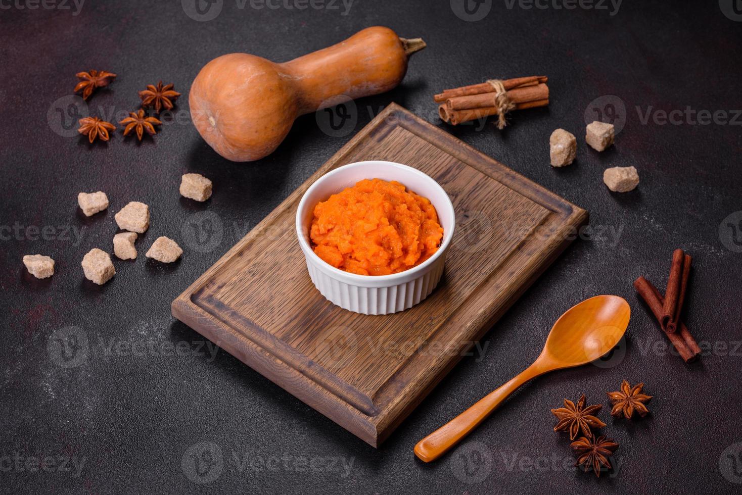 Pumpkin carrot baby puree in bowl on a dark background photo