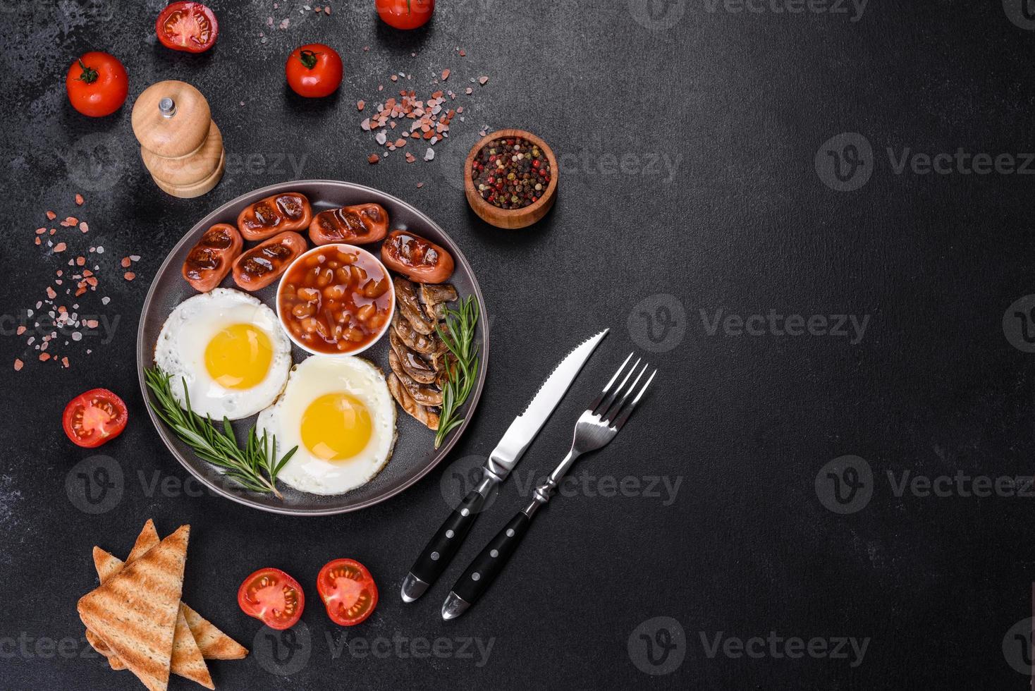 Full english breakfast with bean, fried eggs, roasted sausages, tomatoes and mushrooms photo