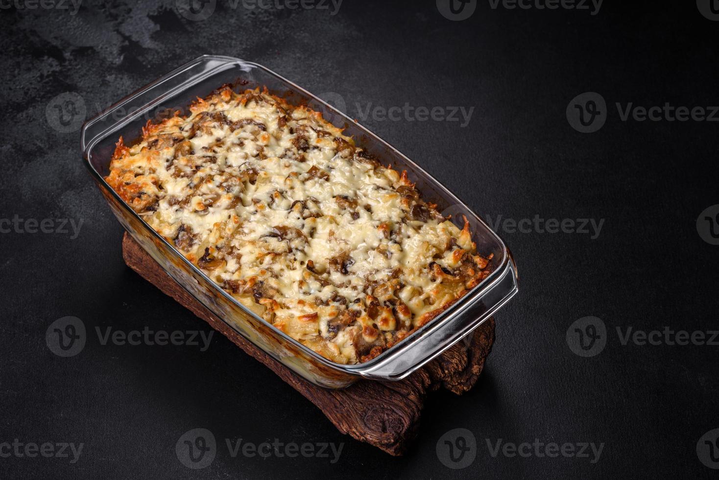 A delicious nutritious dish with meat, mushrooms, vegetables and potatoes, baked in a creamy sauce in an oven photo