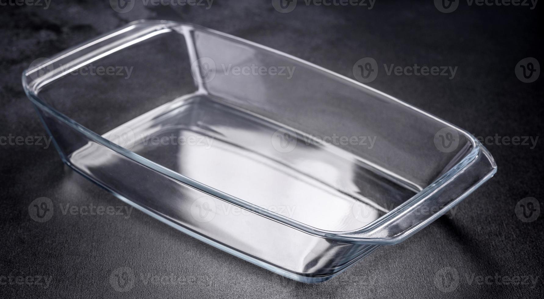 A rectangular glass empty dish for baking on a dark concrete background photo