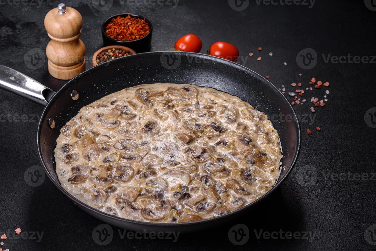 Delicious fresh young champignons sliced into slices in creamy sauce photo