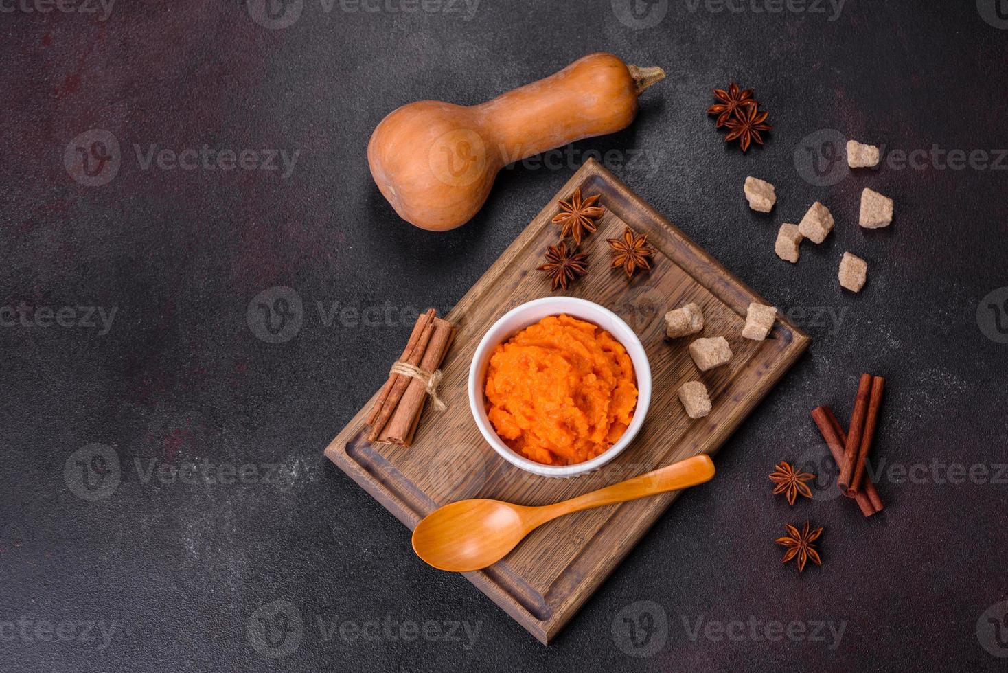 Pumpkin carrot baby puree in bowl on a dark background photo