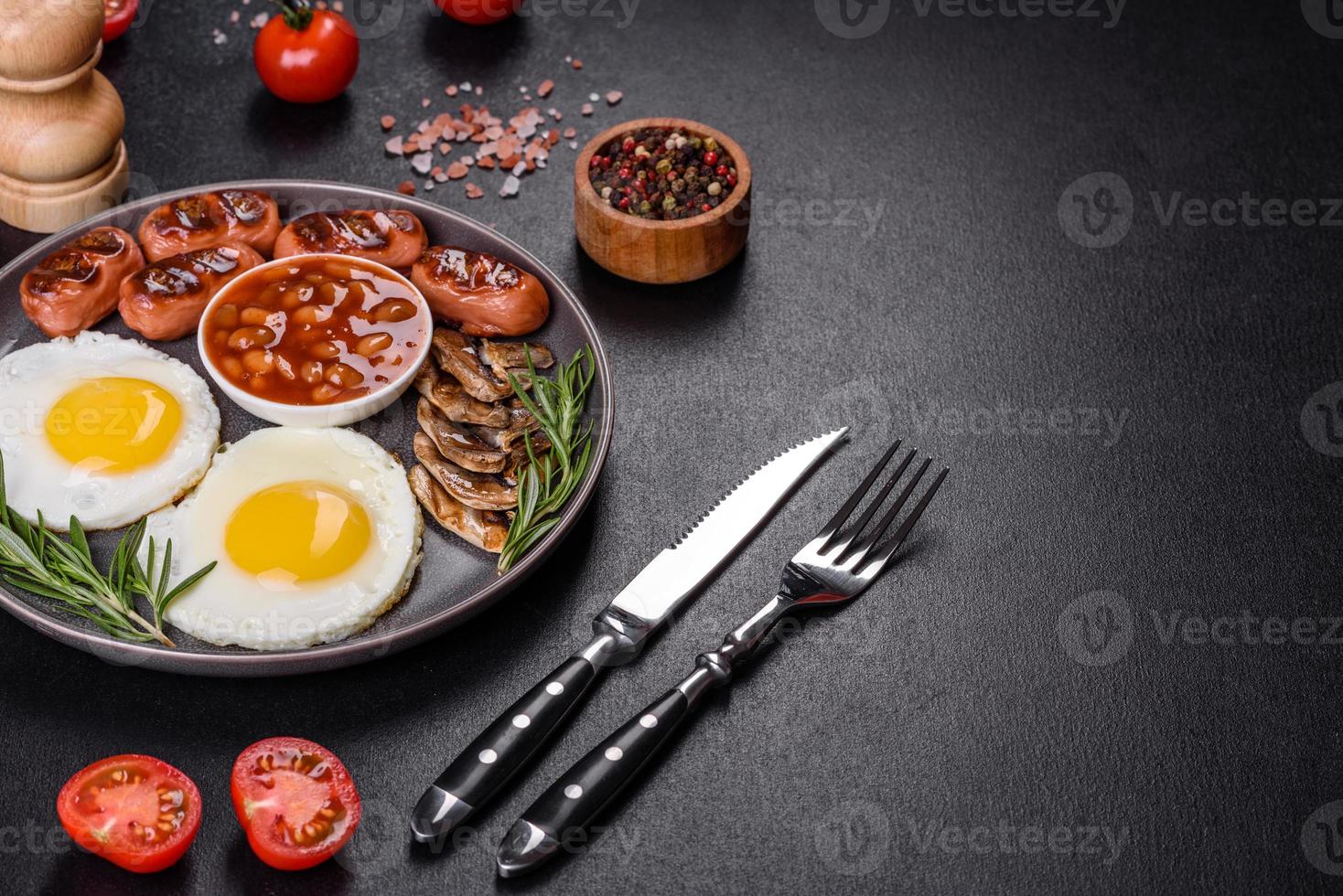 Full english breakfast with bean, fried eggs, roasted sausages, tomatoes and mushrooms photo