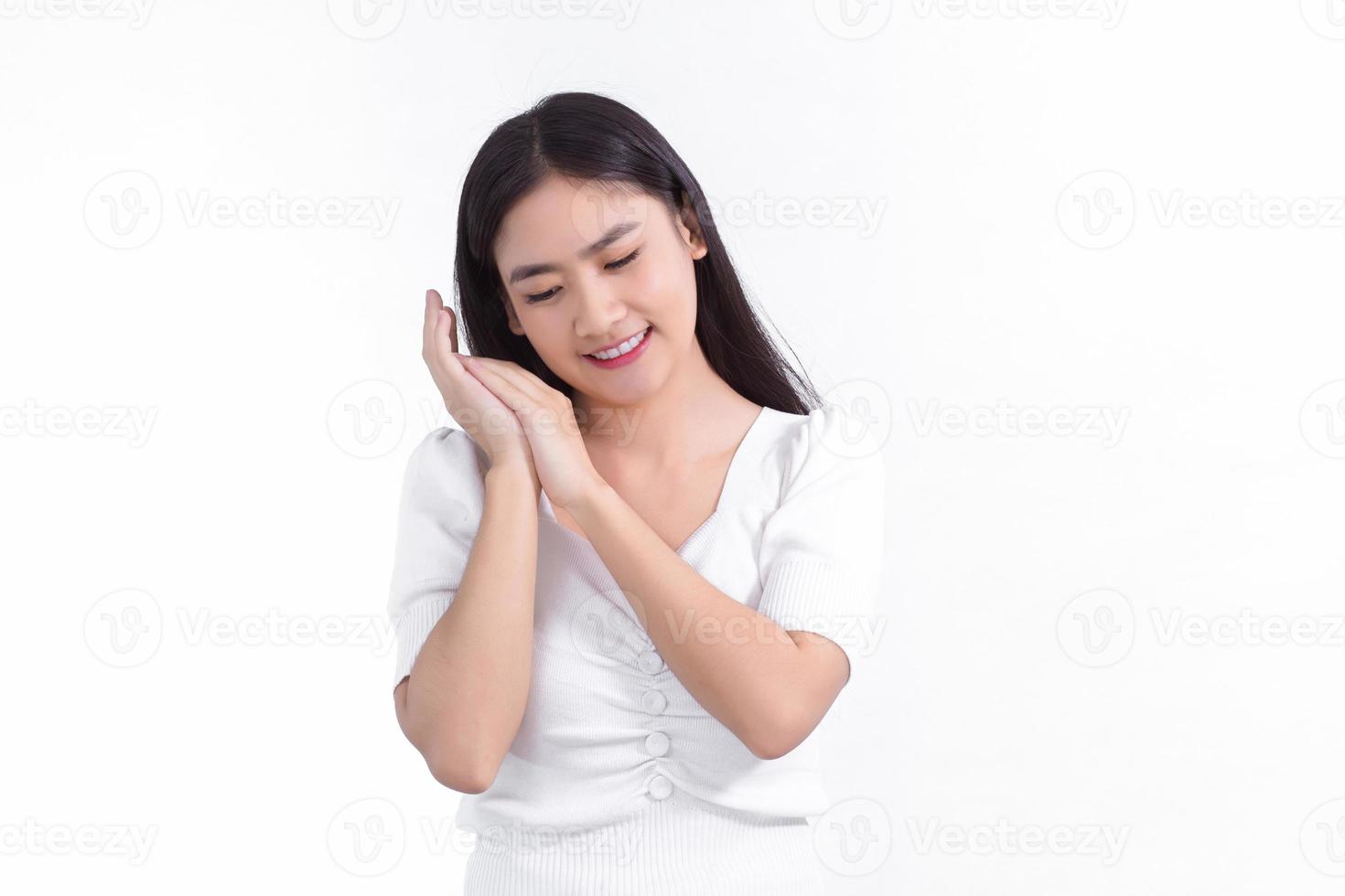 Asian beautiful woman who has long hair smiles and shows her hand near face on white background. photo