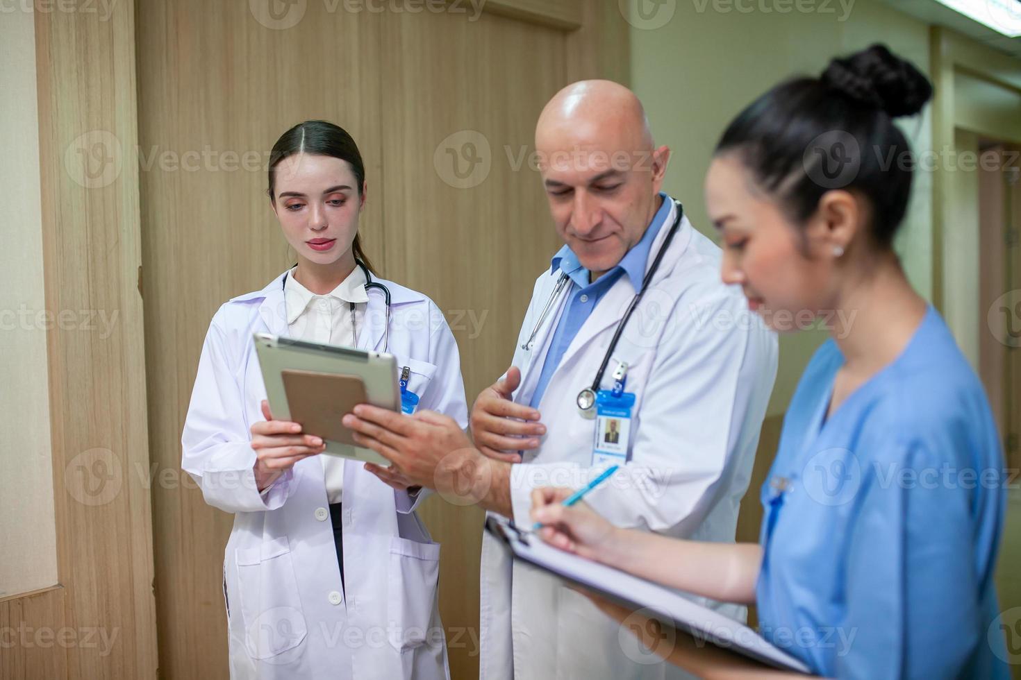 grupo de médicos que consultan los registros de los pacientes, un médico anciano y un colega que discuten la terapia actual de enfermedades en el lugar de trabajo. foto