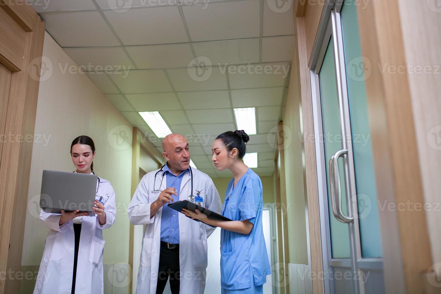 grupo de médicos que consultan los registros de los pacientes, un médico anciano y un colega que discuten la terapia actual de enfermedades en el lugar de trabajo. foto