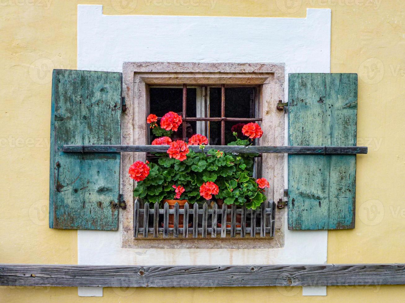 Closeup shot of an old wooden window with flowers on the sill photo