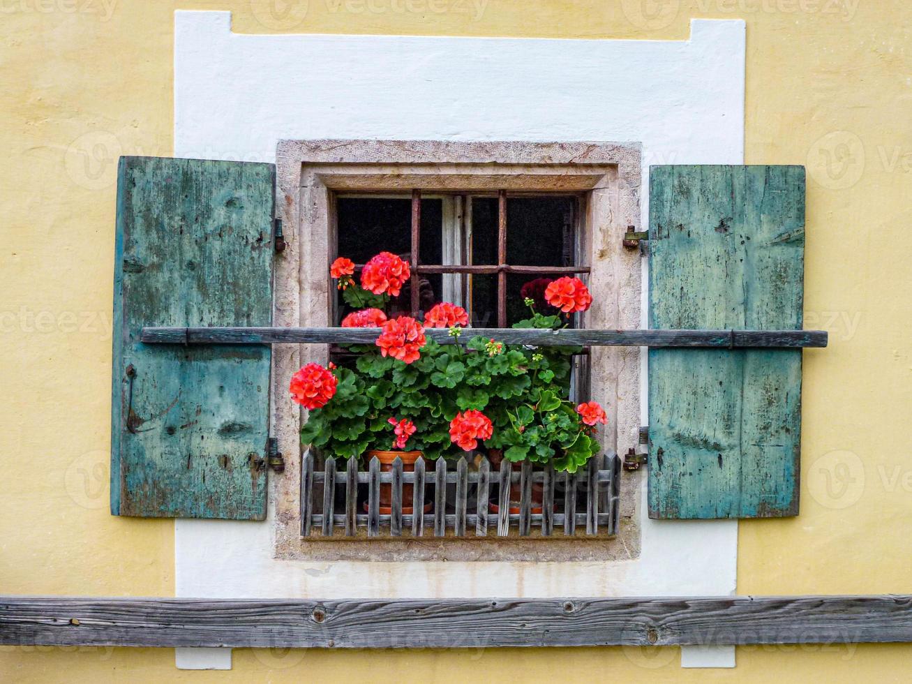 primer plano de una vieja ventana de madera con flores en el alféizar foto