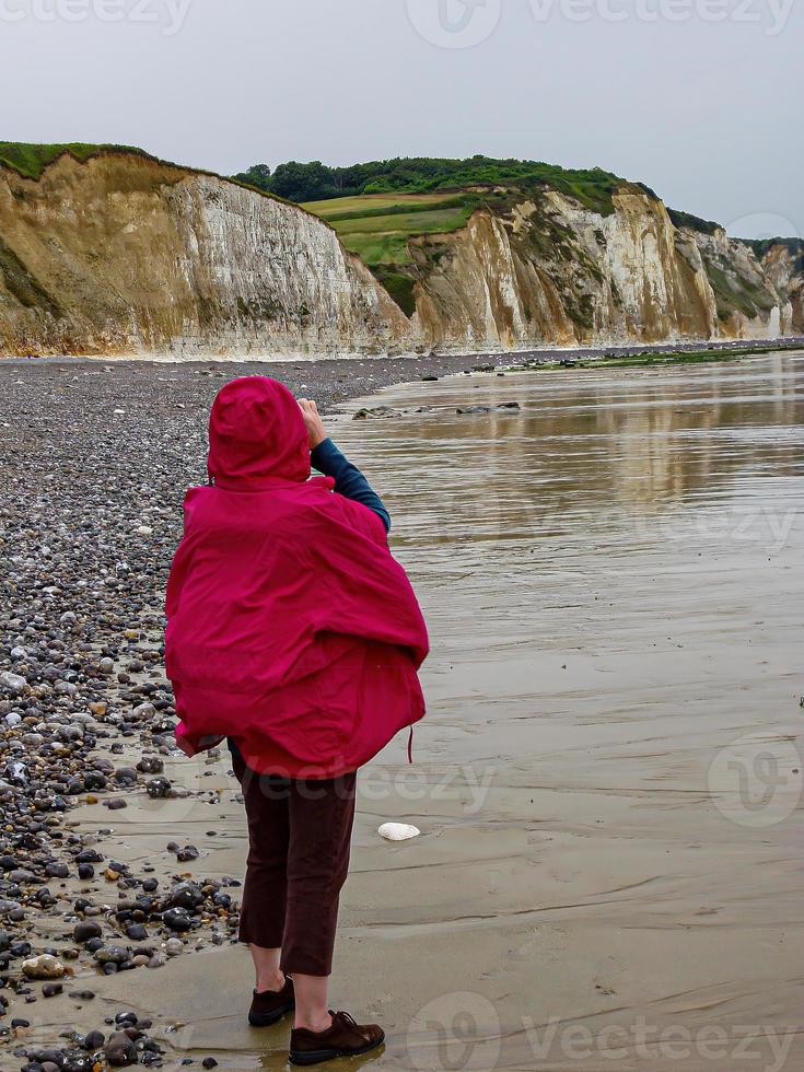 Rear view of the female looking at the high cliffs at Hautot sur Mer in Normandy, France photo