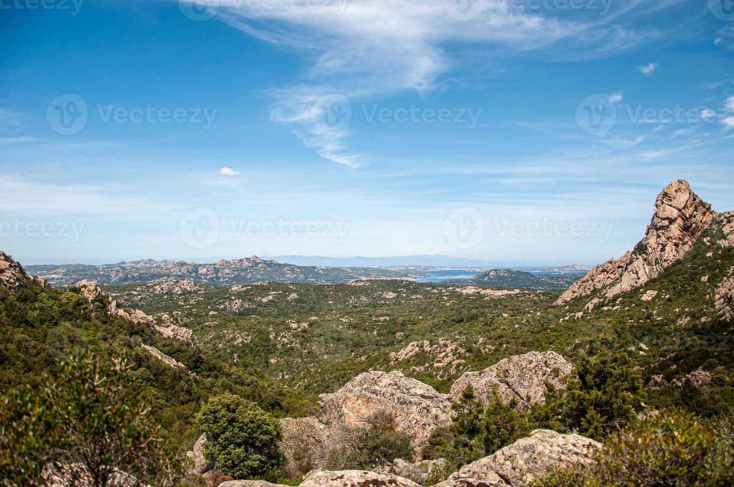 Rural landscape with plants on rocky hills on a sunny day photo