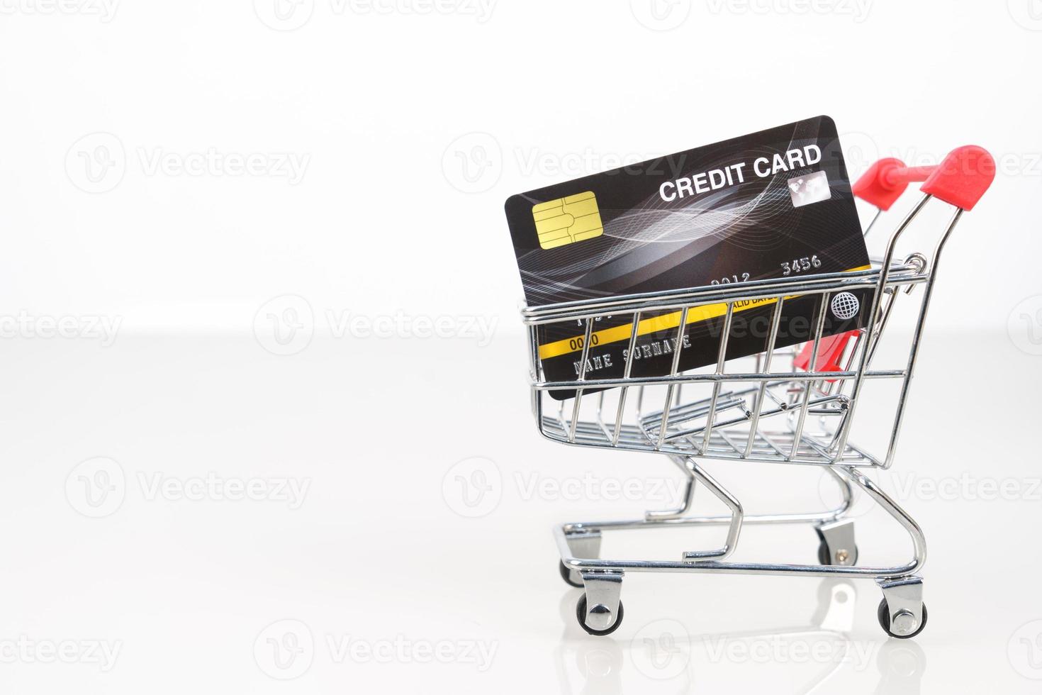 Credit card in shopping cart on white photo