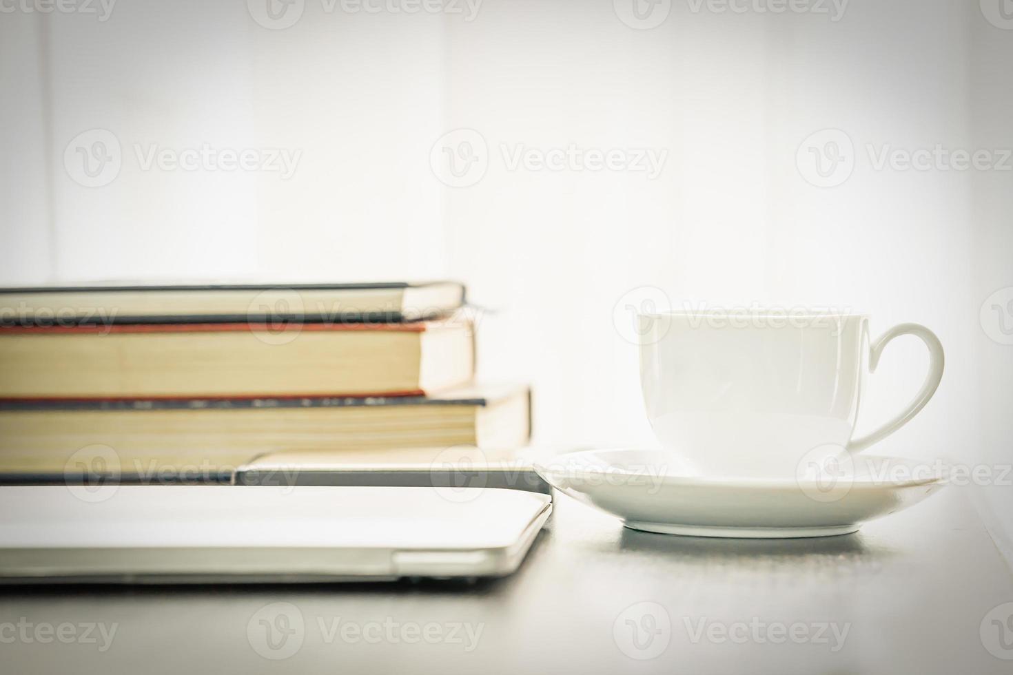 Coffee cup and laptop with book photo