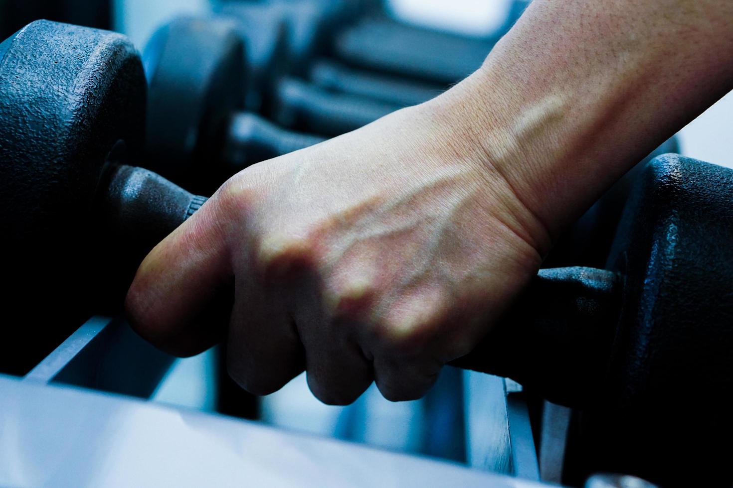 Close up of hand holding dumbbell in fitness. photo