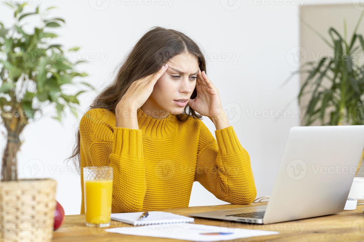 mujer masajeando las sienes de la cabeza debido al dolor de cabeza por un trabajo prolongado foto