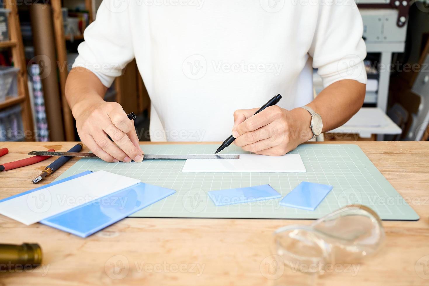Faceless female entrepreneur cutting glass in artisan workroom. Business woman draws line photo
