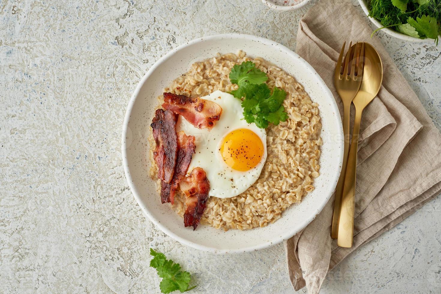 Oatmeal, fried egg, fried bacon. Balanced food. Intuitive conscious food, top view, copy space photo
