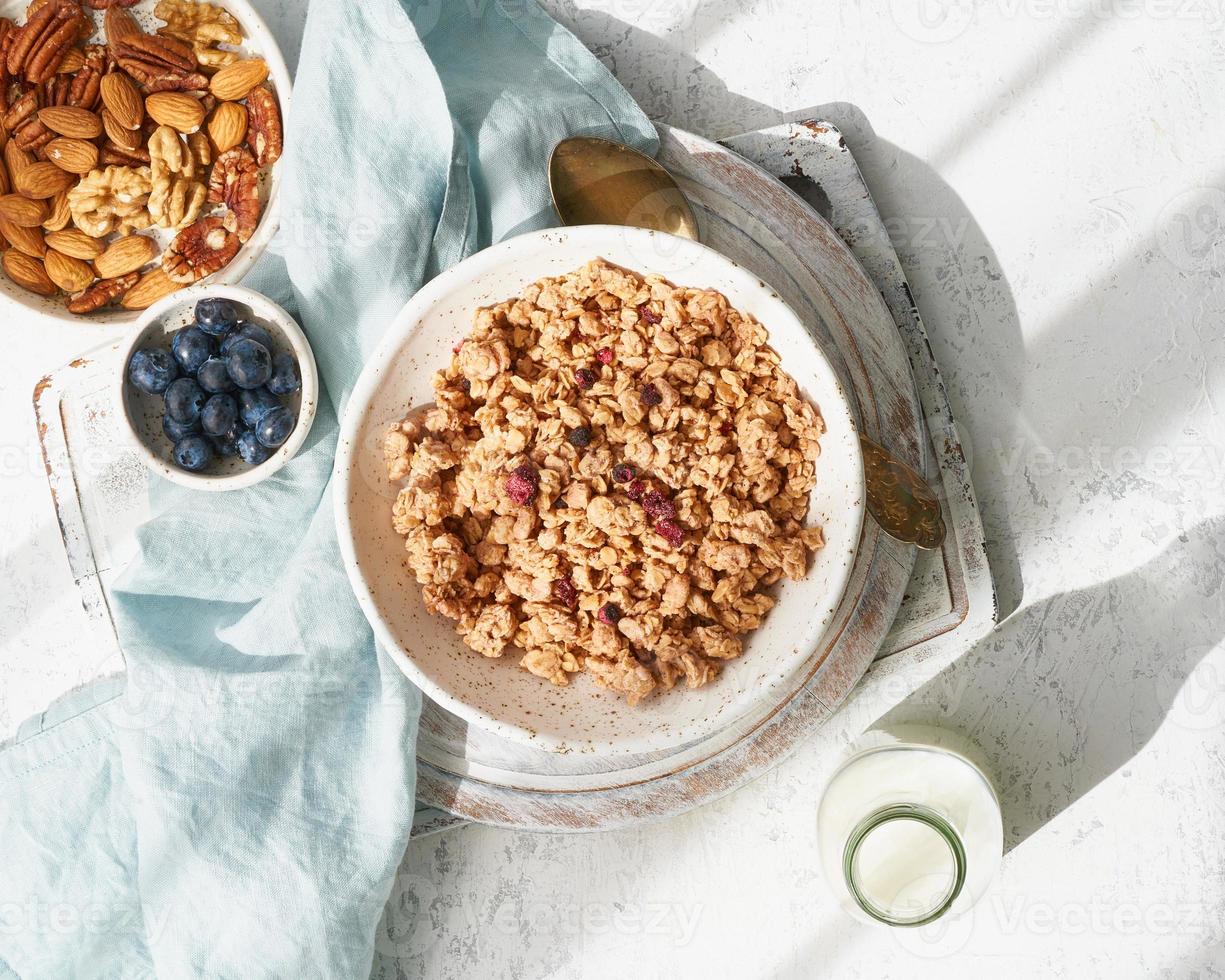 granola seca en un tazón. rayo de sol, luz dura, temprano en la mañana. desayuno, comida de dieta saludable foto