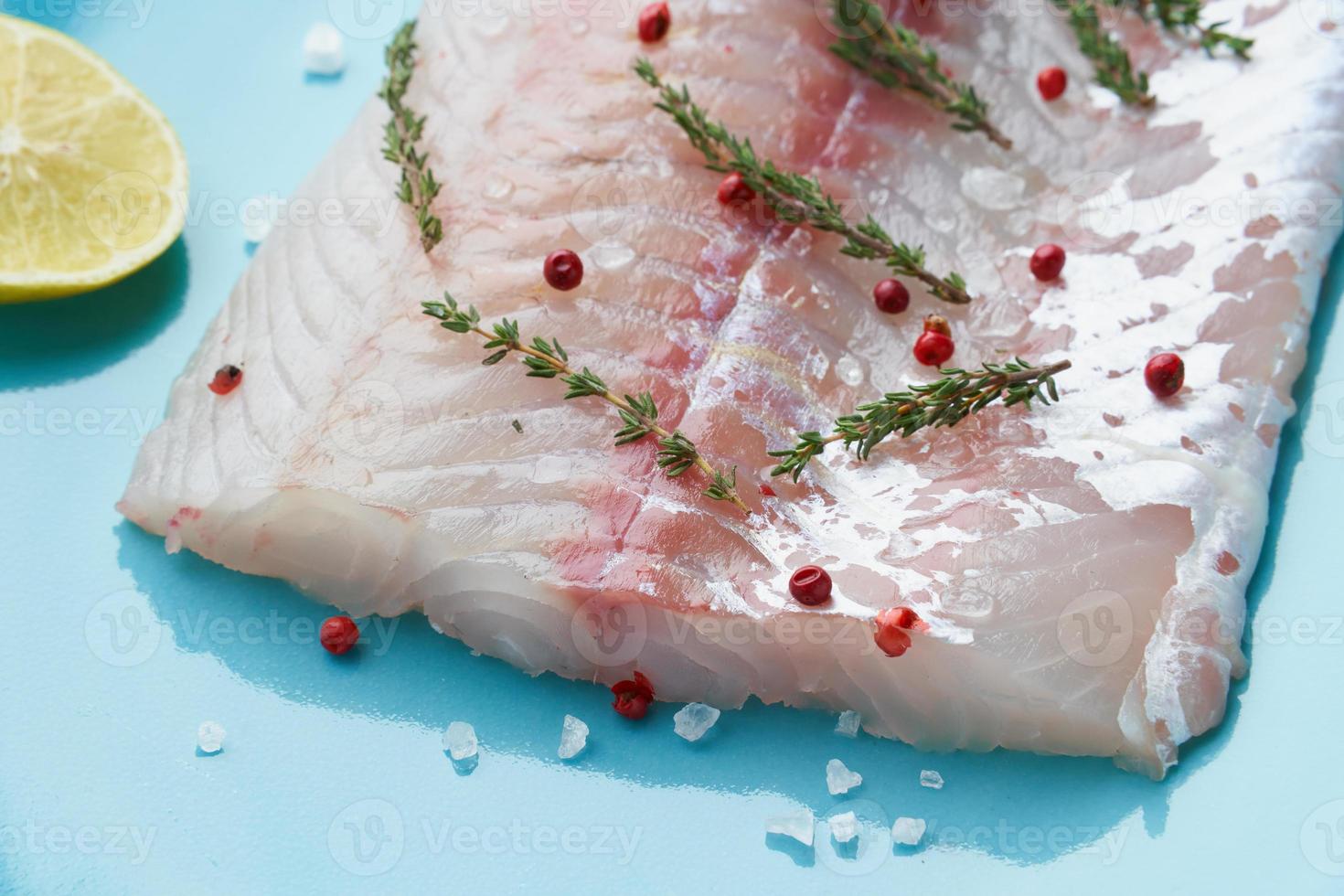 Fillet of raw white walleye fish on a blue plate on a white background. Whole piece of fresh fish photo