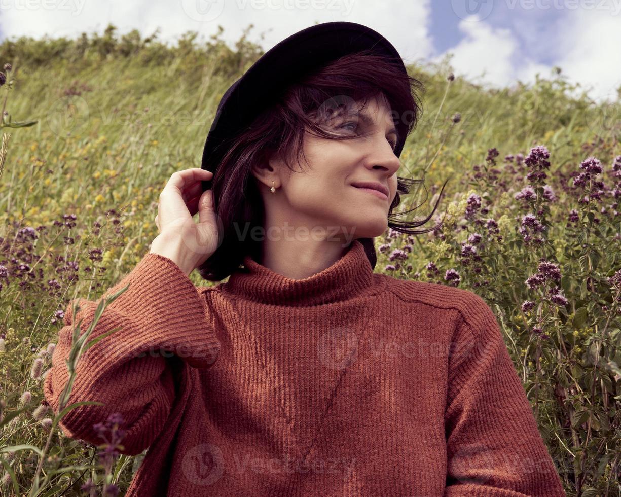 Portrait of adult female in hat sitting in meadow Karelia photo