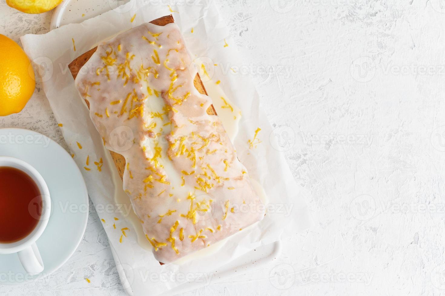 Lemon bread coated with sugar sweet icing and sprinkled with lemon peel. Cake citrus, copy space photo