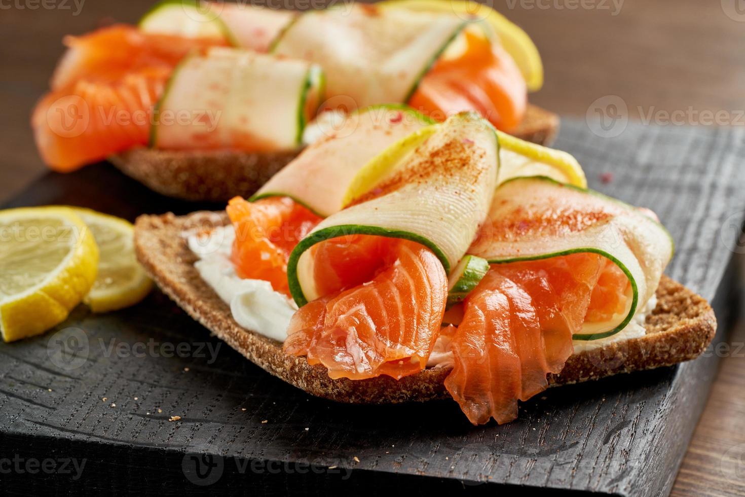 smorrebrod - bocadillos daneses tradicionales. pan de centeno negro con salmón, queso crema foto