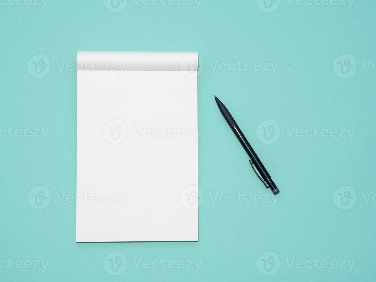 Top view workspace mockup on aqua background with open notebook and pen photo