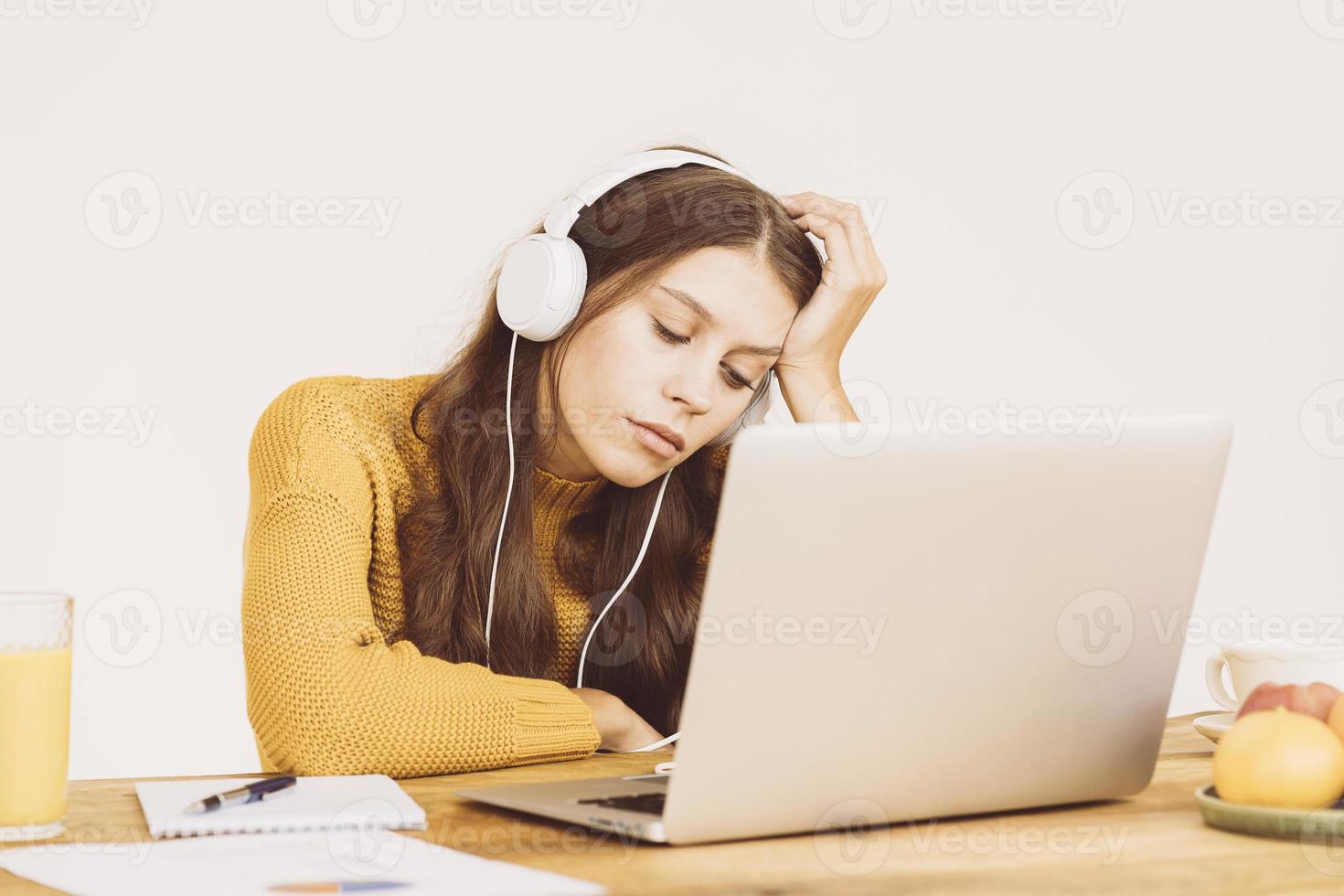 la niña se durmió frente a la computadora portátil. linda mujer esta aburrida foto