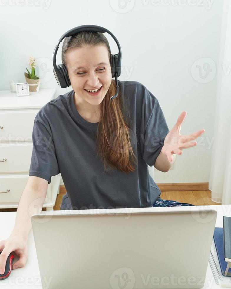 chica con auriculares mira la información en la computadora con sorpresa. foto