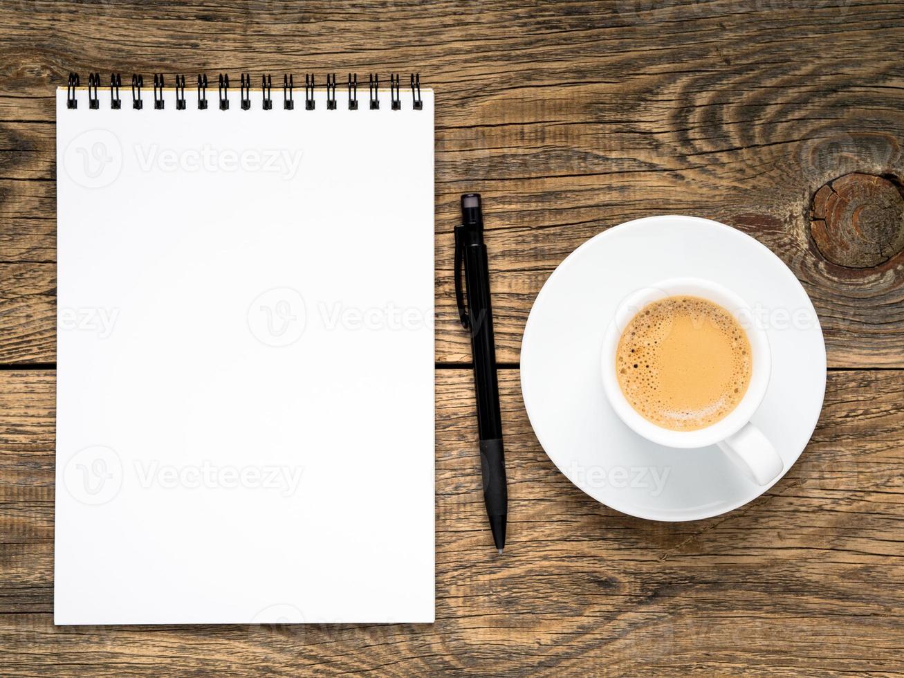 open notepad with spiral, pen and coffee cup photo