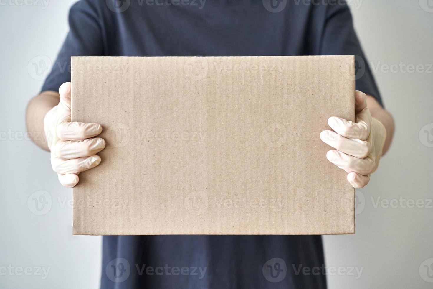 entrega sin contacto de pedidos en línea a la puerta de casa, manos con guantes de goma estériles foto