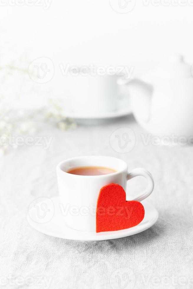 Día de San Valentín. Desayuno matutino para dos con té y flores. corazón de fieltro rojo es símbolo de los amantes foto