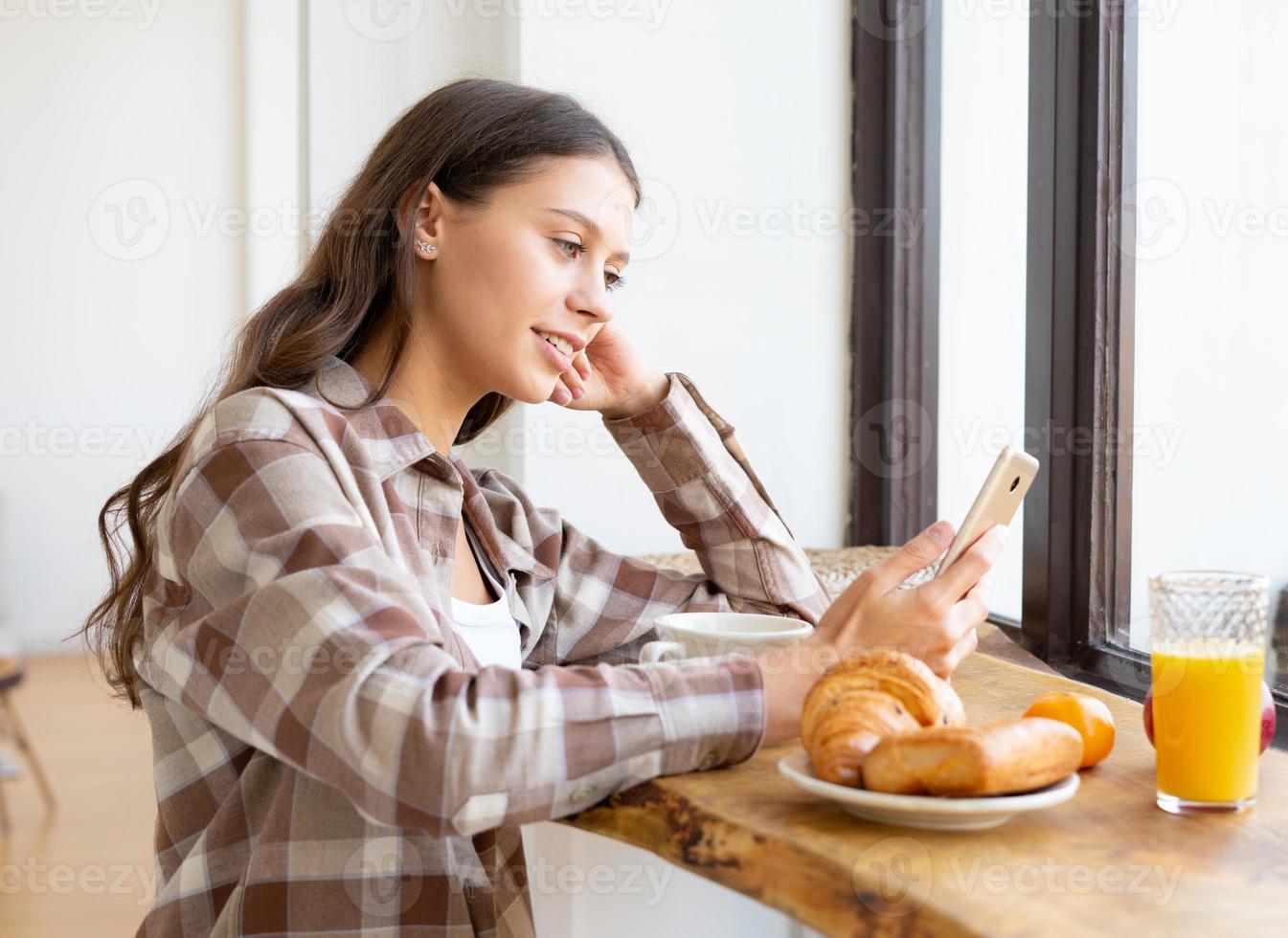 Woman looking for information on Internet, smiling and using mobile, photo