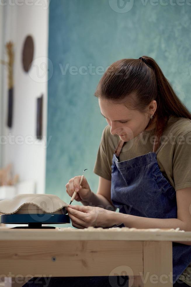 Young girl making ceramic bowl in class. Creative hobby concept photo