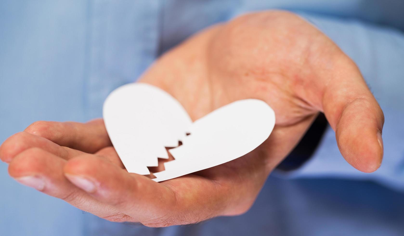 Hand with broken paper heart photo