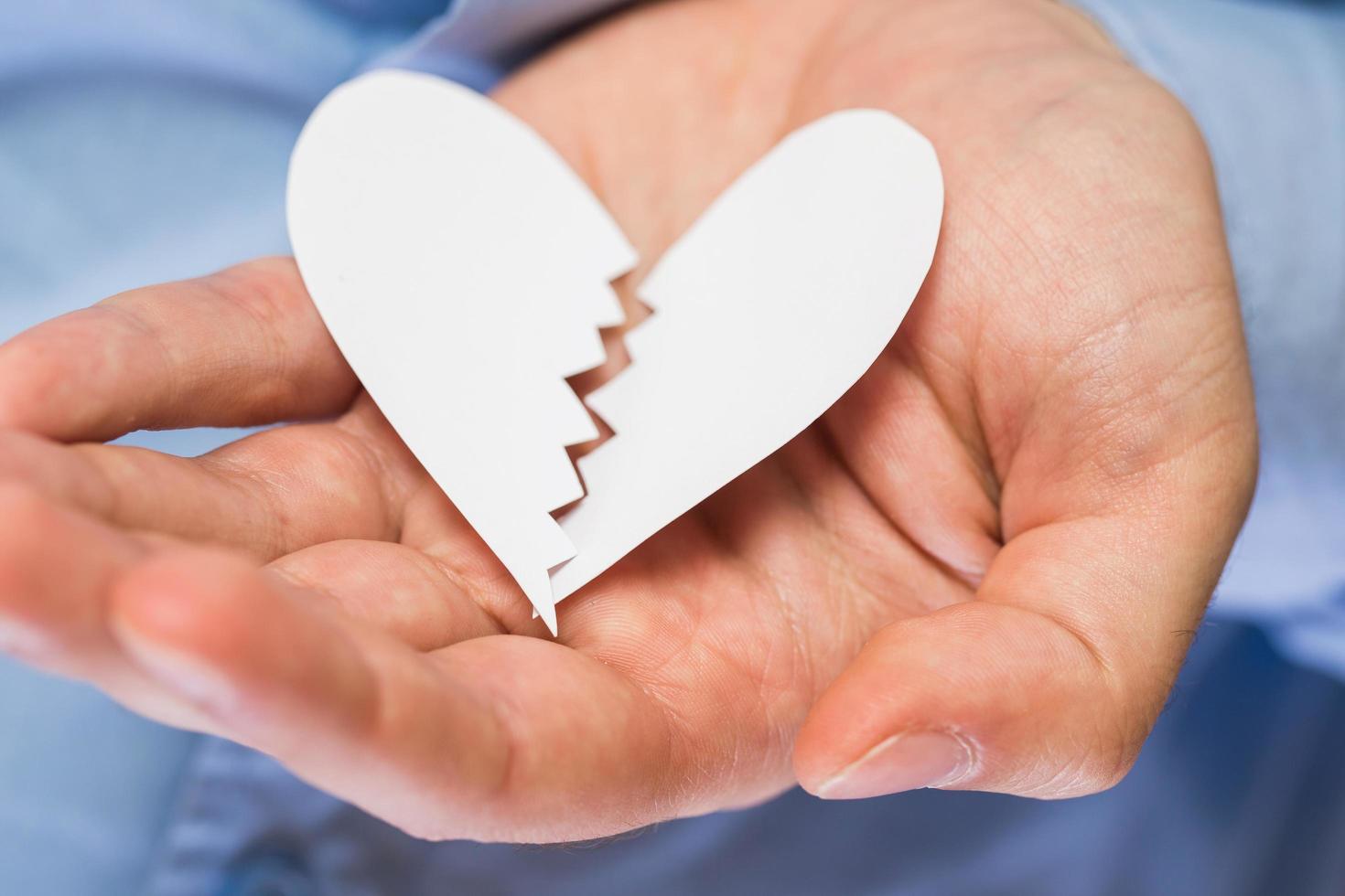 Hand with broken paper heart photo