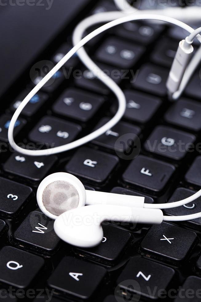 Earphones over keyboard photo