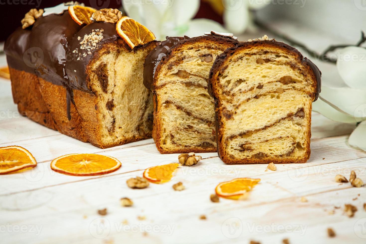 Home Made Panettone. Traditional Italian sweet bread. Panettone with a slice served on a wooden table. photo