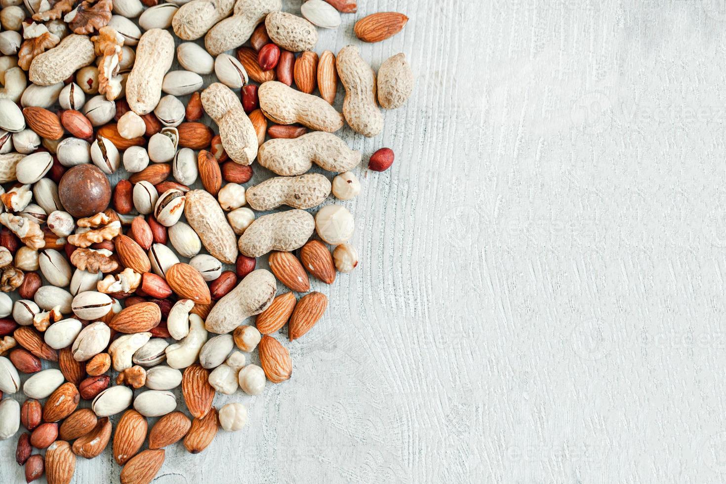 Assorted nuts for a background Almond, walnut,cashew, pistachios, hazelnuts, peanuts, Macadamia Collection of different varieties of nuts. Composition with dried fruits Healthy food. Organic. photo