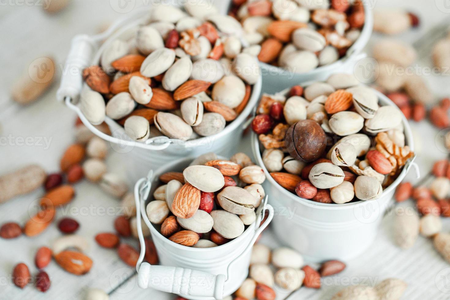 Assorted nuts for a background Almond, walnut,cashew, pistachios, hazelnuts, peanuts, Macadamia Collection of different varieties of nuts. Composition with dried fruits Healthy food. Organic. photo
