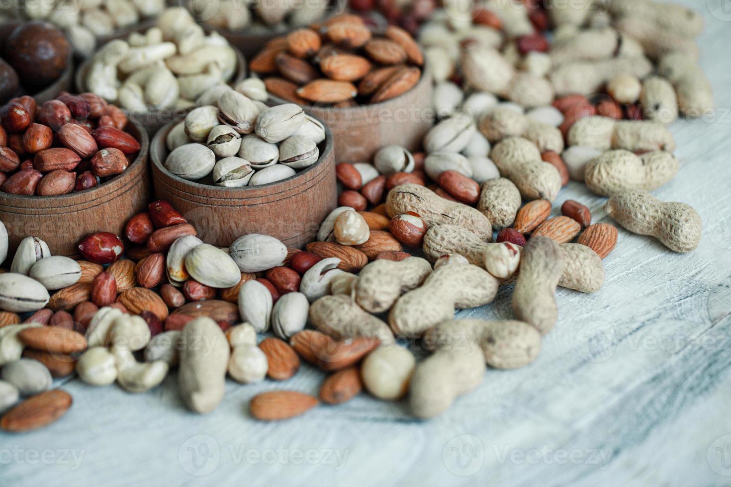 Assorted nuts for a background Almond, walnut,cashew, pistachios, hazelnuts, peanuts, Macadamia Collection of different varieties of nuts. Composition with dried fruits Healthy food. Organic. photo