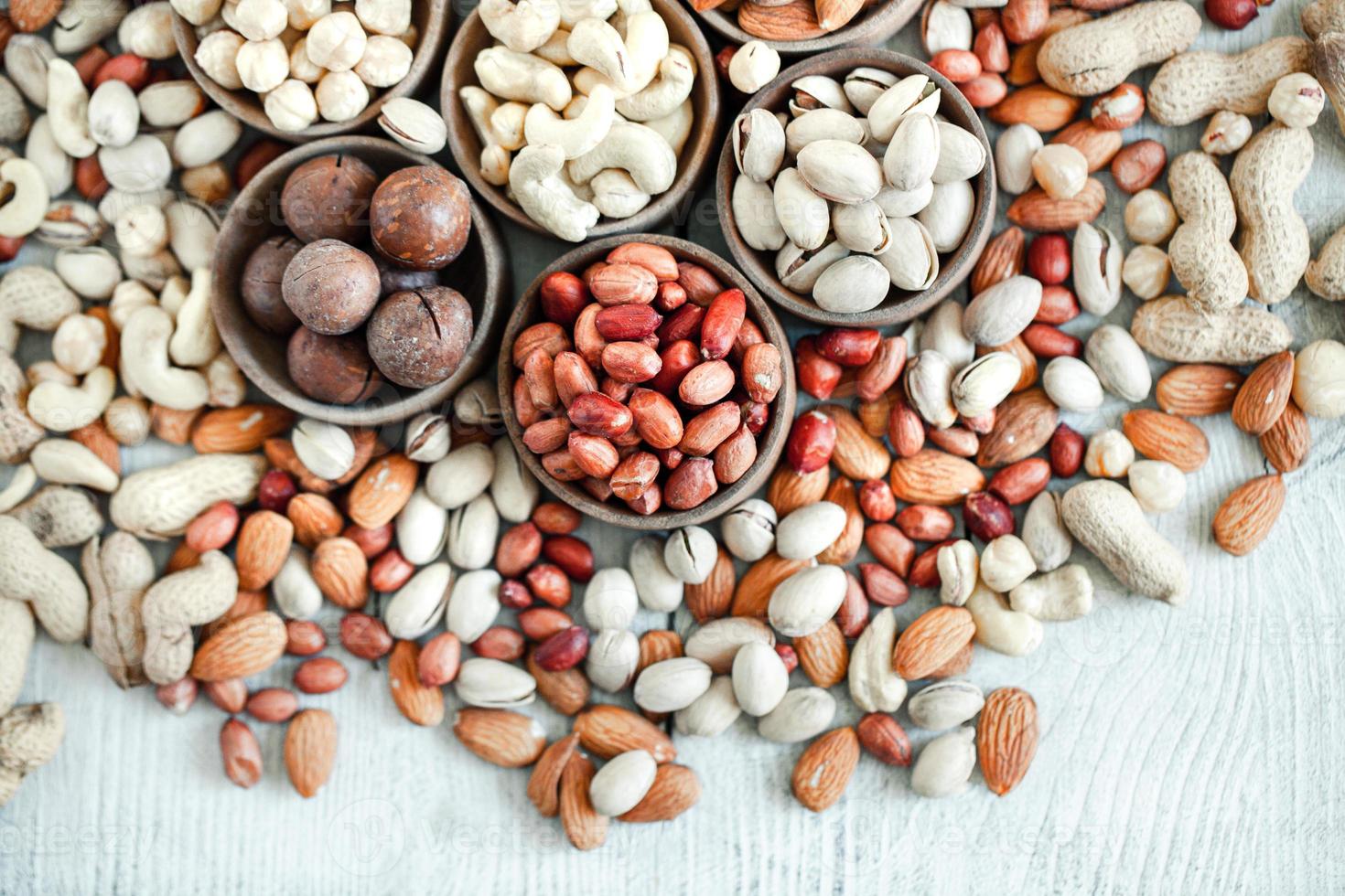 Assorted nuts for a background Almond, walnut,cashew, pistachios, hazelnuts, peanuts, Macadamia Collection of different varieties of nuts. Composition with dried fruits Healthy food. Organic. photo