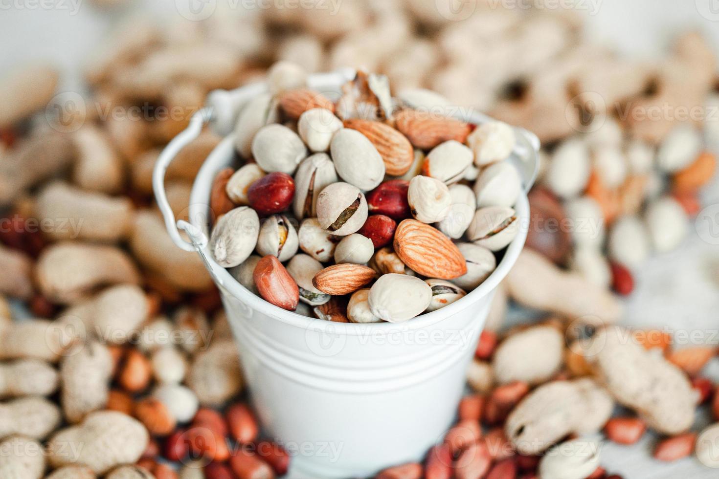 Assorted nuts for a background Almond, walnut,cashew, pistachios, hazelnuts, peanuts, Macadamia Collection of different varieties of nuts. Composition with dried fruits Healthy food. Organic. photo