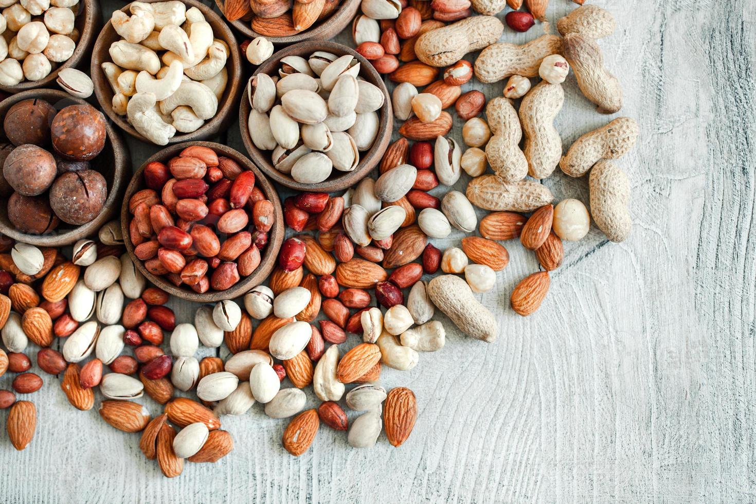 Assorted nuts for a background Almond, walnut,cashew, pistachios, hazelnuts, peanuts, Macadamia Collection of different varieties of nuts. Composition with dried fruits Healthy food. Organic. photo
