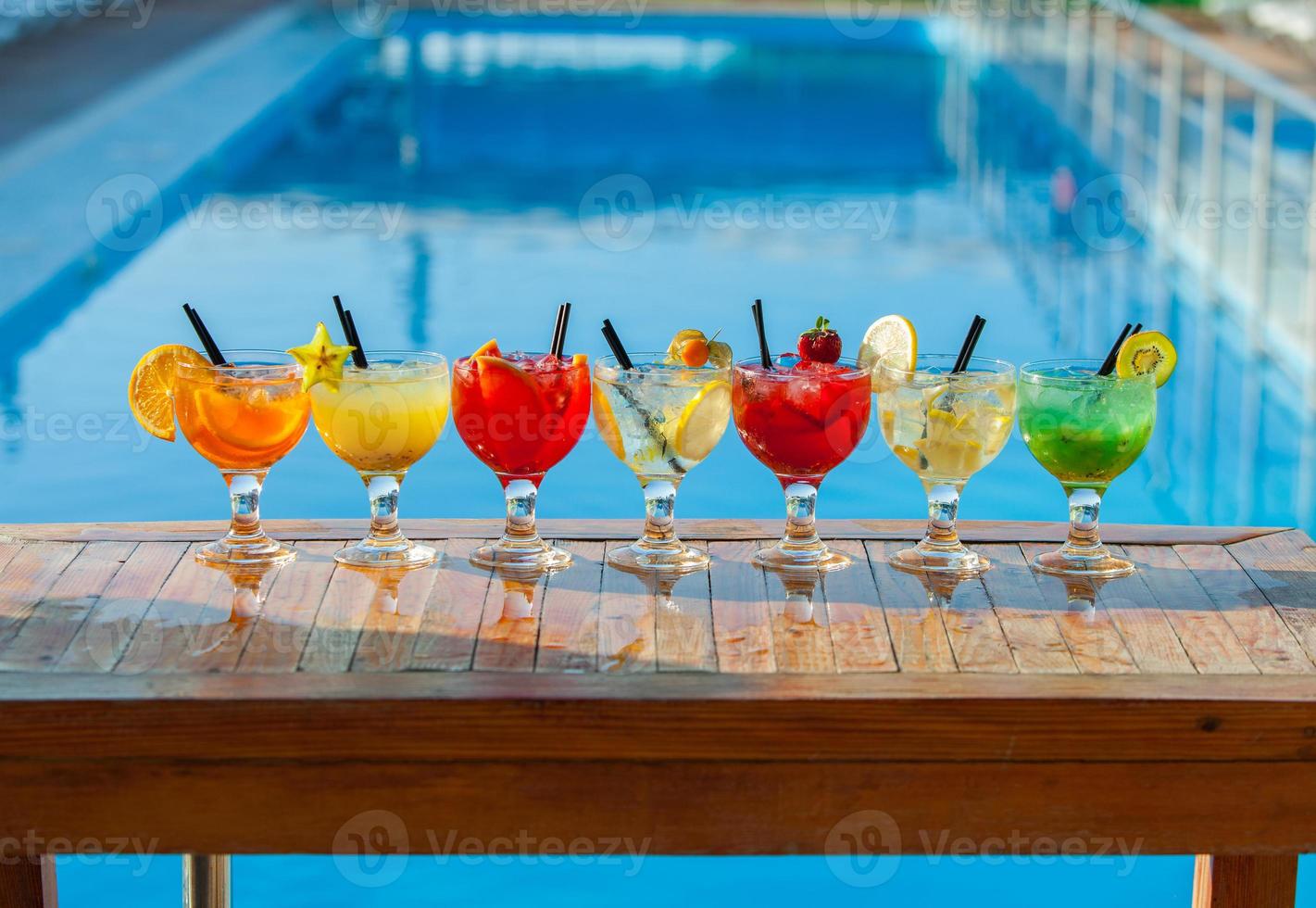 varios cócteles alcohólicos sobre fondo blanco. coloridos cócteles de cerca. bebida de cóctel de jugo de frutas. cócteles variados. vasos de bebidas de frutas con cubitos de hielo en la mesa del café foto