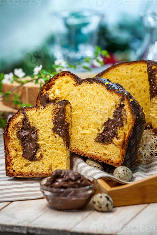 Home Made Panettone. Traditional Italian sweet bread. Panettone with a slice served on a wooden table. photo