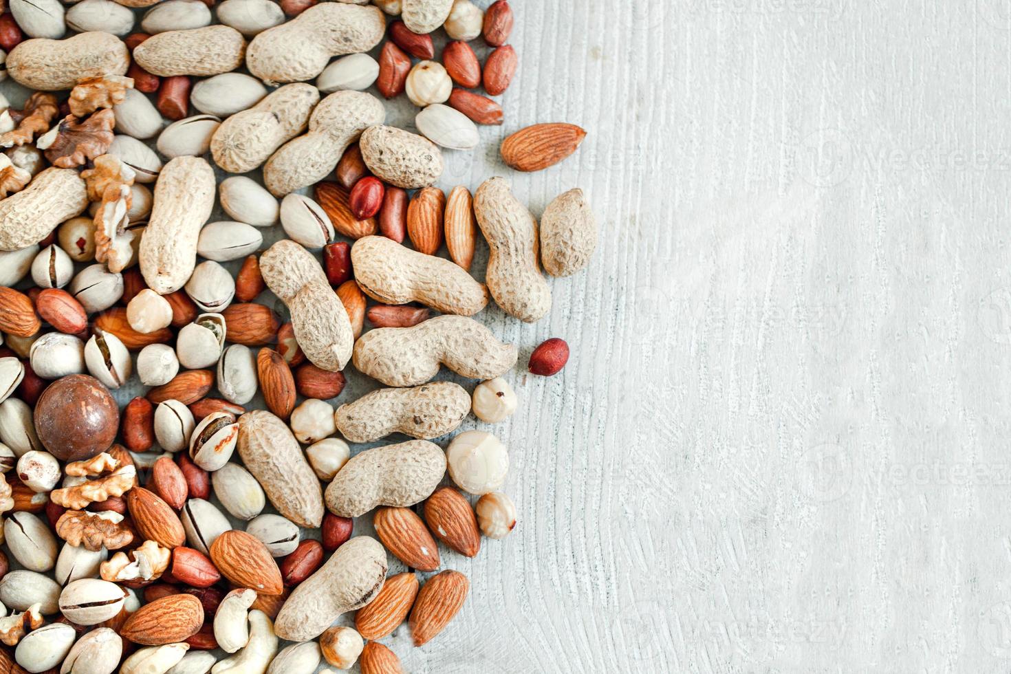 Assorted nuts for a background Almond, walnut,cashew, pistachios, hazelnuts, peanuts, Macadamia Collection of different varieties of nuts. Composition with dried fruits Healthy food. Organic. photo