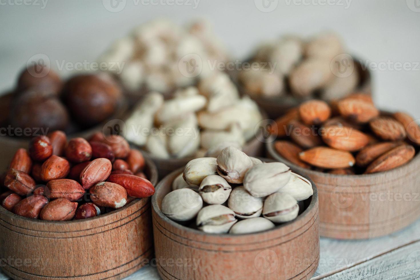 Assorted nuts for a background Almond, walnut,cashew, pistachios, hazelnuts, peanuts, Macadamia Collection of different varieties of nuts. Composition with dried fruits Healthy food. Organic. photo