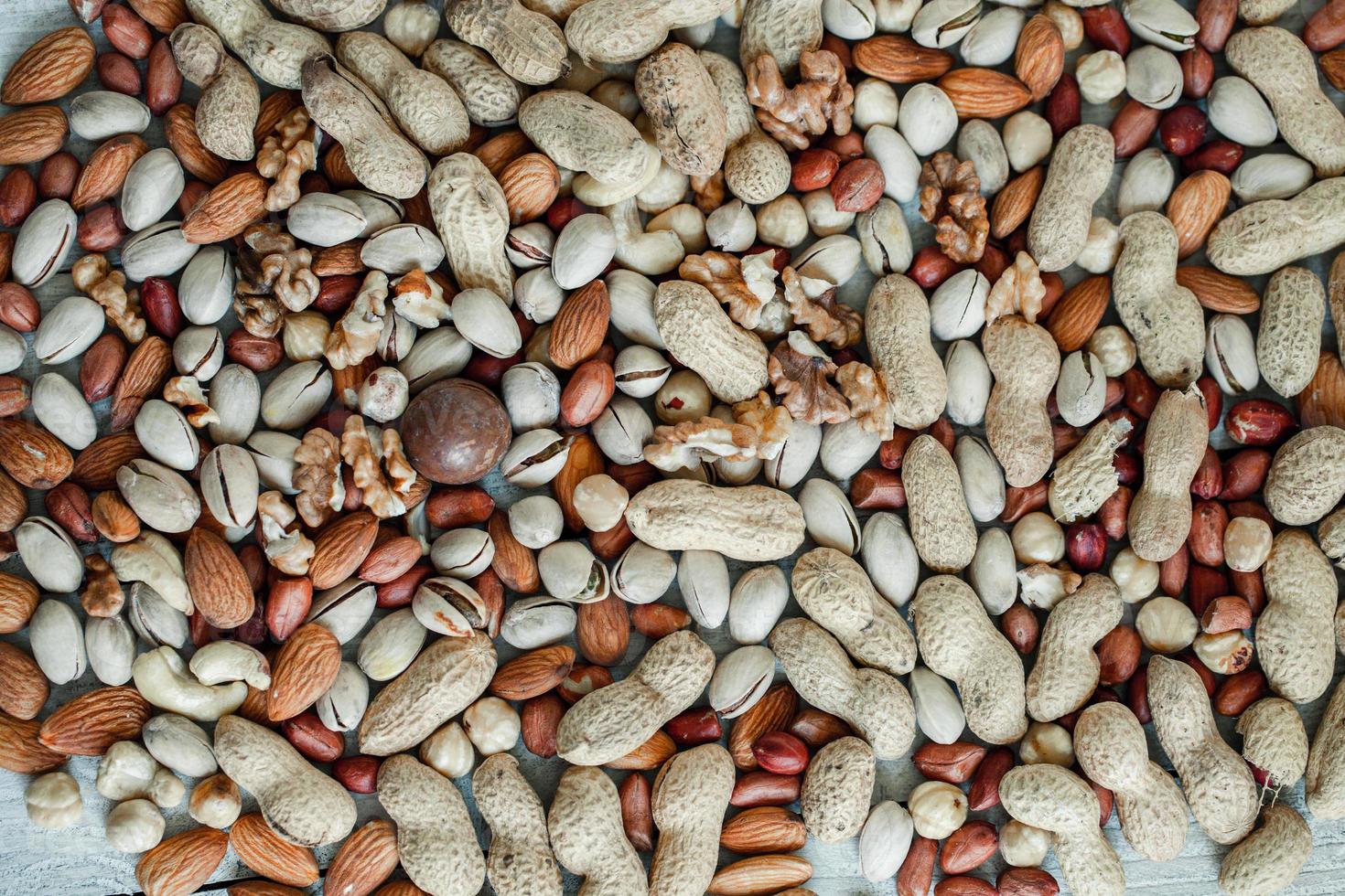 Assorted nuts for a background Almond, walnut,cashew, pistachios, hazelnuts, peanuts, Macadamia Collection of different varieties of nuts. Composition with dried fruits Healthy food. Organic. photo